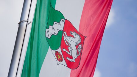 Flagge mit dem Landeswappen von Nordrhein-Westfalen  / © Rolf Vennenbernd (dpa)