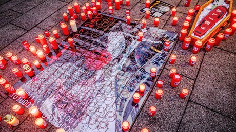 Ein Plakat, brennende Opferlichter und ein symbolischer Sarg bei einer Kundgebung von Betroffenen sexuellen Missbrauchs in der katholischen Kirche am 21. Januar 2022 vor dem Essener Dom. / © Andre Zelck (KNA)