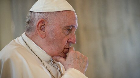 Papst Franziskus stützt seinen Kopf auf eine Hand und blickt gedankenversunken / ©  Vatican Media/Romano Siciliani (KNA)