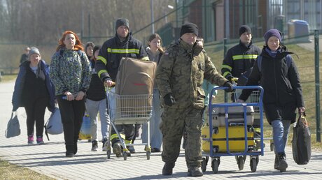 Aus der Ukraine geflüchtete Personen kommen am polnisch-ukrainischen Grenzübergang in Medyka an. / © Sergei Grits/AP (dpa)