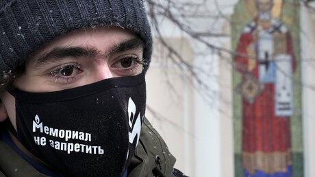 Ein Unterstützer der Menschenrechtsgruppe Memorial, der eine Gesichtsmaske mit der Aufschrift Das Memorial kann nicht verboten werden trägt / © Alexander Zemlianichenko (dpa)