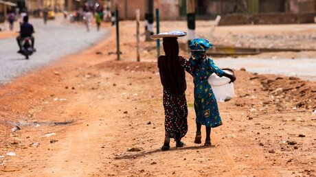 Mädchen mit Eimer für Wasserversorgung in Nigeria / © Teo-Inspiro International (shutterstock)
