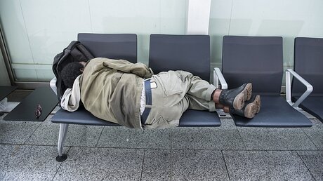 Ein Obdachloser schläft auf Stühlen / © Heike Lyding (epd)