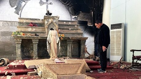 Priester im Altarraum seiner zerstörten Kirche in Karamles / © N.N. (KiN)