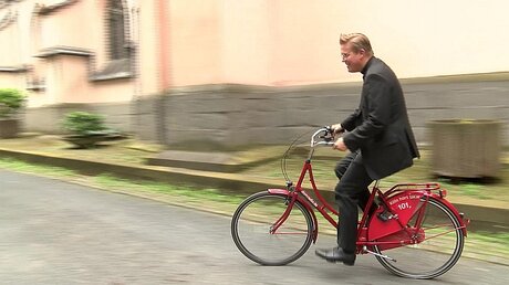 Kölner Innenstadtpfarrer Meiering fährt ein DOMRADIO.DE-Fahrrad / © domradio.de (DR)