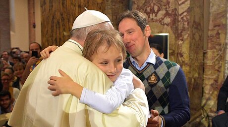 Papst Franziskus umarmt ein kleines Mädchen am 1. Oktober 2017 in Bologna / © Osservatore Romano (KNA)
