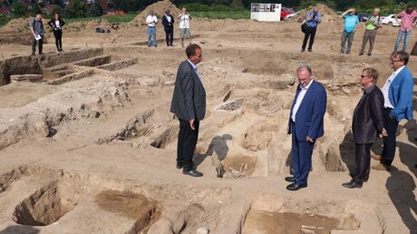 Auch der Ministerpräsident von Sachsen-Anhalt, Reiner Haseloff, schaut sich die Ausgrabungen bei Helfta an / © Ronny Hartmann (dpa)