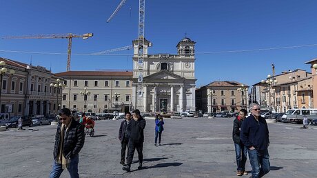 Baukräne und Absperrgitter auf einem großen Platz in der Altstadt in L'Aquila / © Stefano dal Pozzolo (KNA)