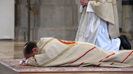 Bertram Meier, neuer Bischof der Diözese Augsburg, liegt während der Bischofsweihe im Dom vor dem Altar auf dem Boden / © Karl-Josef Hildenbrand (dpa)