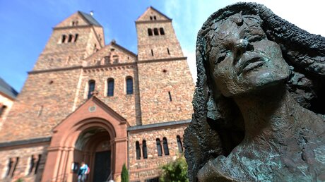 Bronzestatue der Heiligen Hildegard von Bingen vor der Kirche der Abtei St. Hildegard in Rüdesheim / © Arne Dedert (dpa)