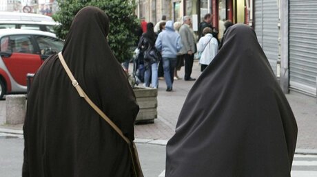Zwei Frauen mit Burka laufen durch eine französische Innenstadt. Hier ist Vollverschleireung eigentlich verboten.  (dpa)