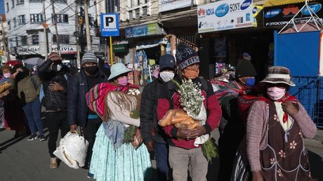 Coronavirus in Bolivien: Menschen stehen mit Atemcshutzmasken in einer Schlange / © Juan Karita/AP (dpa)