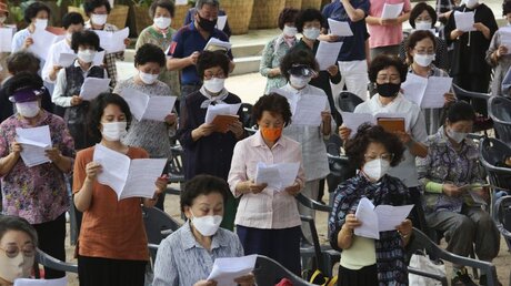 Coronavirus - Südkorea: Menschen, die zum Schutz vor der Verbreitung des Coronavirus Gesichtsmasken tragen, beten während eines Gottesdienstes / © Ahn Young-Joon/AP (dpa)