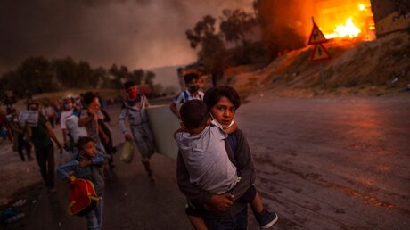 Das "Unicef-Foto des Jahres" zeigt Kinder, die aus dem brennenden Flüchtlingslager Moria auf derInsel Lesbos fliehen / © Angelos Tzortzinis, Griechenland/AFP via Unicef Deutschland (dpa)