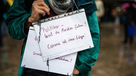 Demonstrant mit Schildern gegen die Corona-Maßnahmen / © Christoph Schmidt (dpa)