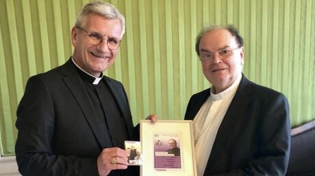 Der Kölner Weihbischof Dominikus Schwaderlapp übergibt Bertram Meier symbolisch die neue Quartettkarte (DR)