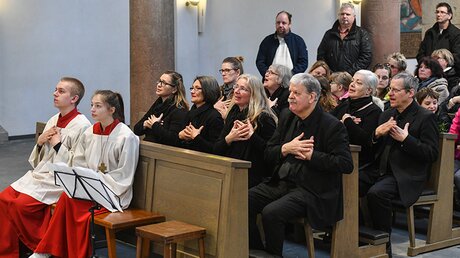 Die Hörbehinderten sitzen auf der einen Seite der Kirche, die hörenden auf der anderen.  (KNA)
