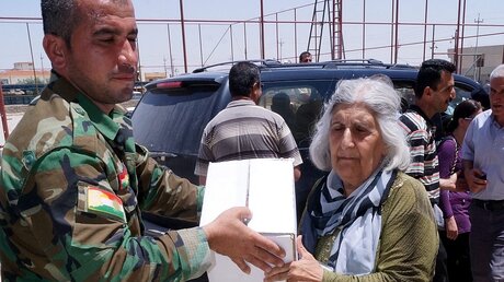 Kurdischer Soldat verteilt Lebensmittel an Christen (dpa)