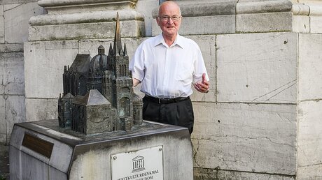 Dompropst Manfred von Holtum neben einem Modell des Aachener Doms / © Julia Steinbrecht (KNA)
