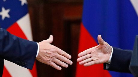 Donald Trump (l) und Wladimir Putin (r) geben sich die Hand  / © Alexander Zemlianichenko (dpa)