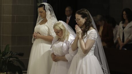 Drei Frauen in Brautkleidern beten vor ihrer Weihe / © Joel Breidenbach (KNA)