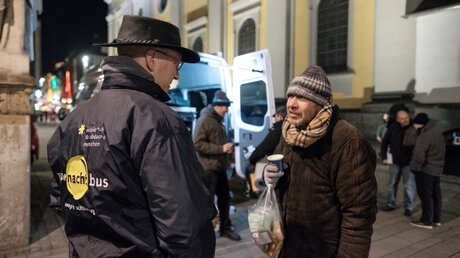 Ehrenamtlicher Helfer spricht mit einem Obdachlosen / © Rudolf Wichert (KNA)