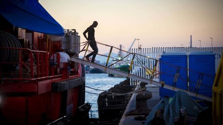 Ein aus Seenot geretteter Migrant geht von Bord eines Schiffs vom spanischen Seerettungsdienst / © Marcos Moreno (dpa)