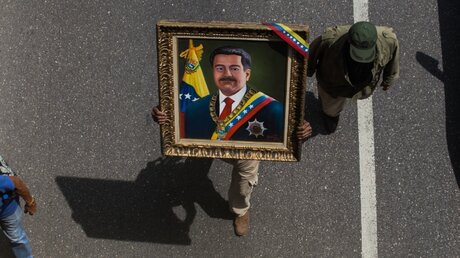 Ein Mann trägt ein Portrait des venezolanischen Präsidenten Maduro / © Ruben Sevilla Brand (dpa)