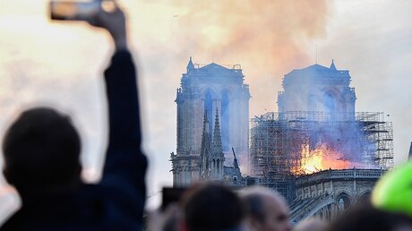 Ein Passant fotografiert den Brand der Kathedrale Notre-Dame / © Julien Mattia (dpa)