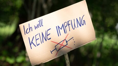 Ein Schild mit der Aufschrift "Ich will keine Impfung" / © Sebastian Kahnert (dpa)