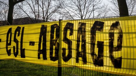 Ein Transparent mit der Aufschrift "ESL - Absage", hängt an einem Zaun gegenüber der Geschäftsstelle von Bundesligist Borussia Dortmund / © Bernd Thissen (dpa)