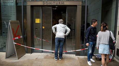 Touristen vor dem abgesperrten Eingang zur Turmbesteigung des Doms / © Marius Becker (dpa)