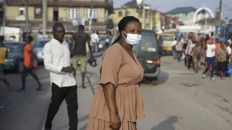 Eine Frau mit Mund-Nasen-Schutz in Nigeria / © Sunday Alamba (dpa)