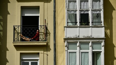 Eine Frau sitzt in Spanien auf ihrem Balkon während der Ausgangssperre / © Alvaro Barrientos/AP (dpa)