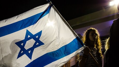 Eine junge Frau mit einer großen Israel-Fahne in Jerusalem / © Sebi Berens (KNA)