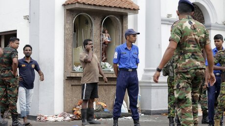 Einsatzkräfte stehen nach einer Explosion vor dem St. Anthony's Shrine in Colombo / © Eranga Jayawardena/AP (dpa)