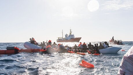 Flüchtlinge, die auf Booten von Libyen aus nach Italien übersetzen wollten, werden während eines Rettungseinsatzes vor der libyschen Küste geborgen. / © Laurin Schmid/SOS (dpa)