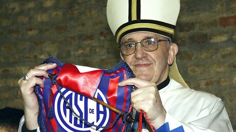 Franziskus mit einem Wimpel von San Lorenzo / © Fußballtrikot mit Papst-Porträt  (dpa)
