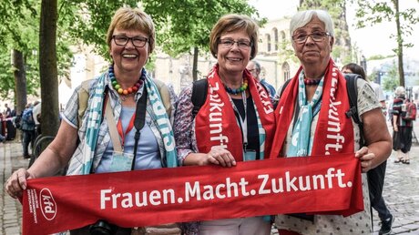 Frauen halten einen Schal mit dem kfd-Logo / © Julia Steinbrecht (KNA)