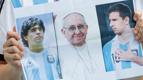 Argentinischer Fußballfan mit Poster: Maradona, Papst Franziskus & Messi / © David Vincent (dpa)