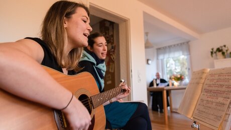 Gemeinsames Singen während eines Wohnzimmergottesdienstes  / © Nicolas Armer (dpa)