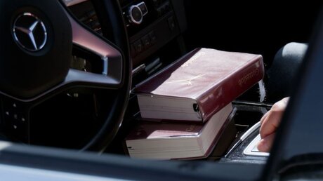Gesangsbücher liegen während des Drive-In-Gottesdienstes in einem Fahrzeug / © Peter Steffen (dpa)