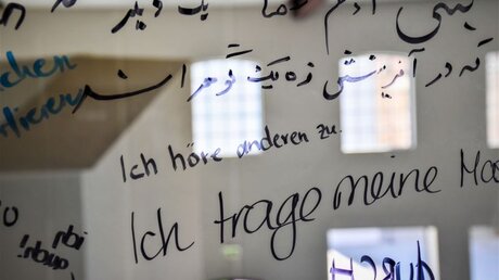 Glashaus mit vielen Zitaten von Besuchern zum Thema Solidarität, zum Beispiel "Ich höre anderen zu", im Augsburger Textilmuseum / © Christopher Beschnitt (KNA)