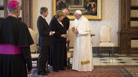 Papst Franziskus mit Angela Merkel und ihrem Ehemann Joachim Sauer nach der Audienz / © Guido Bergmann/Bundesregierung (dpa)