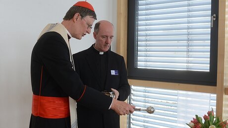  Im Beisein von Dechant Assmann segnet Kardinal Woelki die Kreuze der neuen Einrichtungsräume. / © Beatrice Tomasetti (DR)