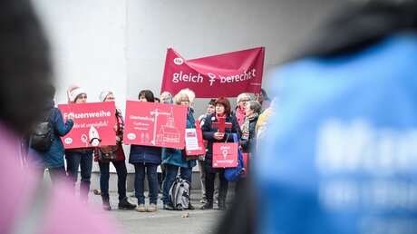 Mitglieder der Initiative Maria 1.0 demonstrieren beim Auftakt zur fünften Synodalversammlung am 9. März 2023 in Frankfurt. Im Hintergrund stehen Frauen der Initiative Maria 2.0. / © Julia Steinbrecht (KNA)
