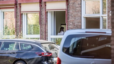 Eine Person steht im Fenster des erzbischöflichen Hauses am 27. Juni 2023 in Köln, während Ermittler der Staatsanwaltschaft Köln eine Durchsuchung im Haus durchführen / © Theodor Barth (KNA)
