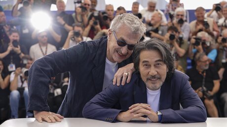 Wim Wenders (l), Regisseur aus Deutschland, und der Schauspieler Koji Yakusho in Cannes / © Vianney Le Caer (dpa)