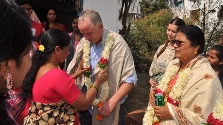 Michael Müller-Offermann wird mit einer Mala, einer für den Hinduismus typischen Kette aus frischen Blumen, geehrt. (BONO)