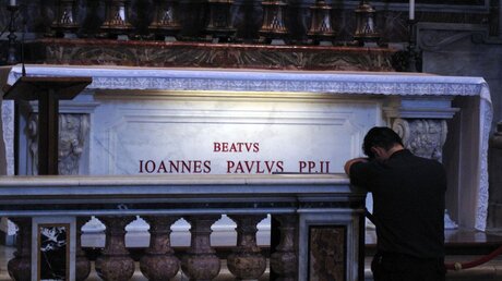 Betender am Grab von Johannes Paul II. im Petersdom (Archiv) (KNA)